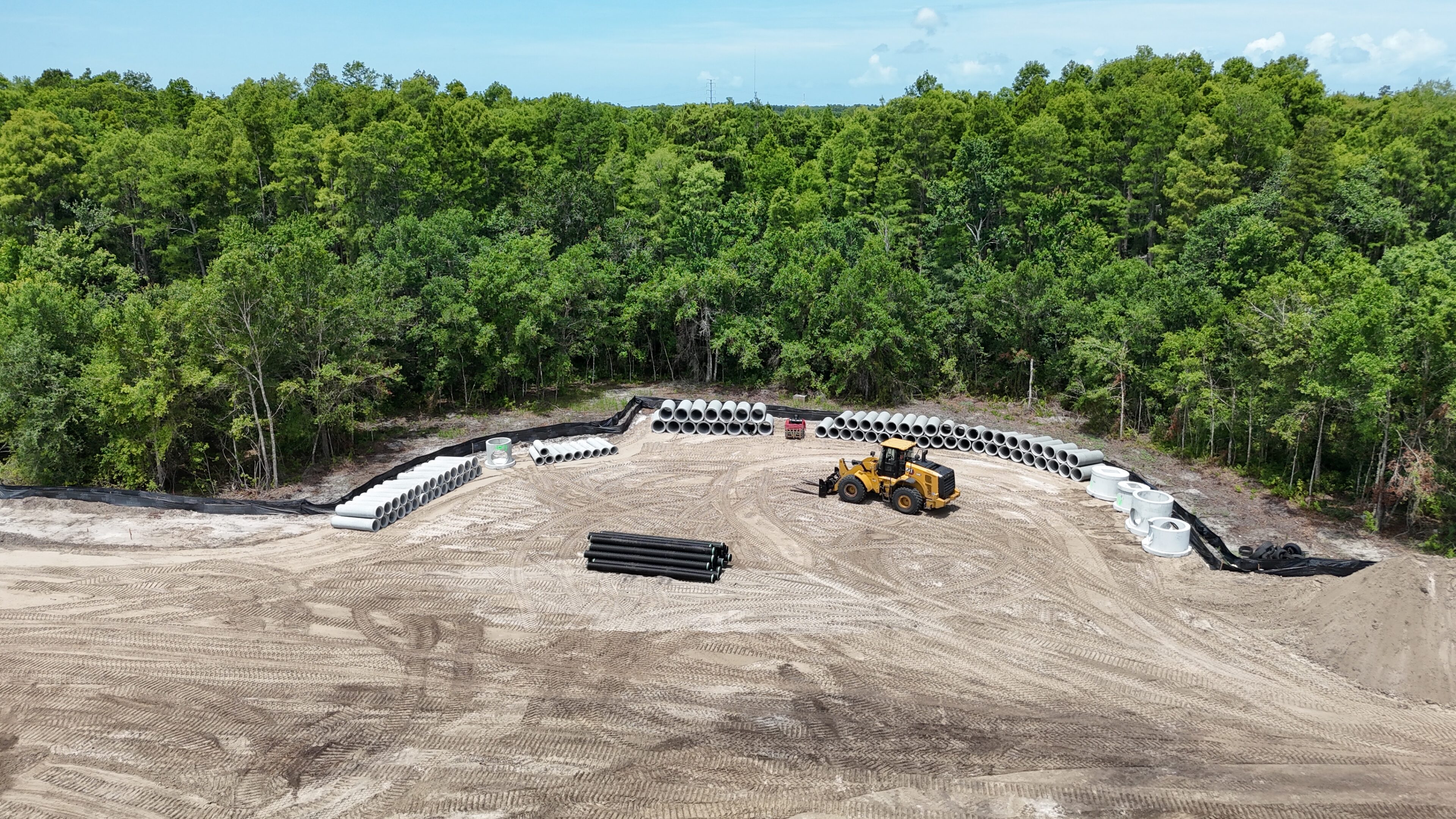 Construction site with loader and concrete pipes