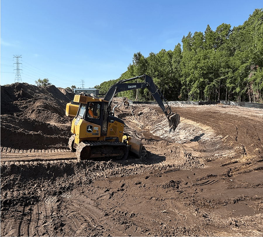 Yellow excavator digging soil at construction site