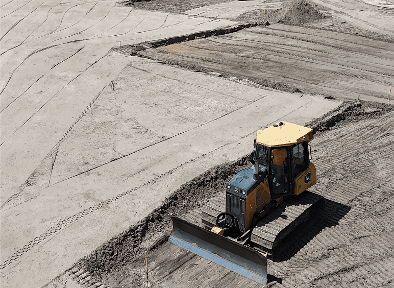 Bulldozer leveling soil at construction site