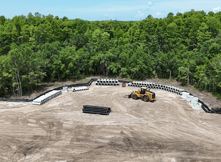 Construction site with loader and concrete pipes